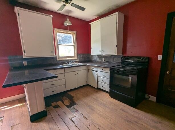 kitchen with decorative backsplash, sink, electric range, white cabinets, and light hardwood / wood-style floors