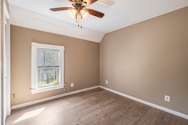 unfurnished room with ceiling fan, light wood-type flooring, and vaulted ceiling