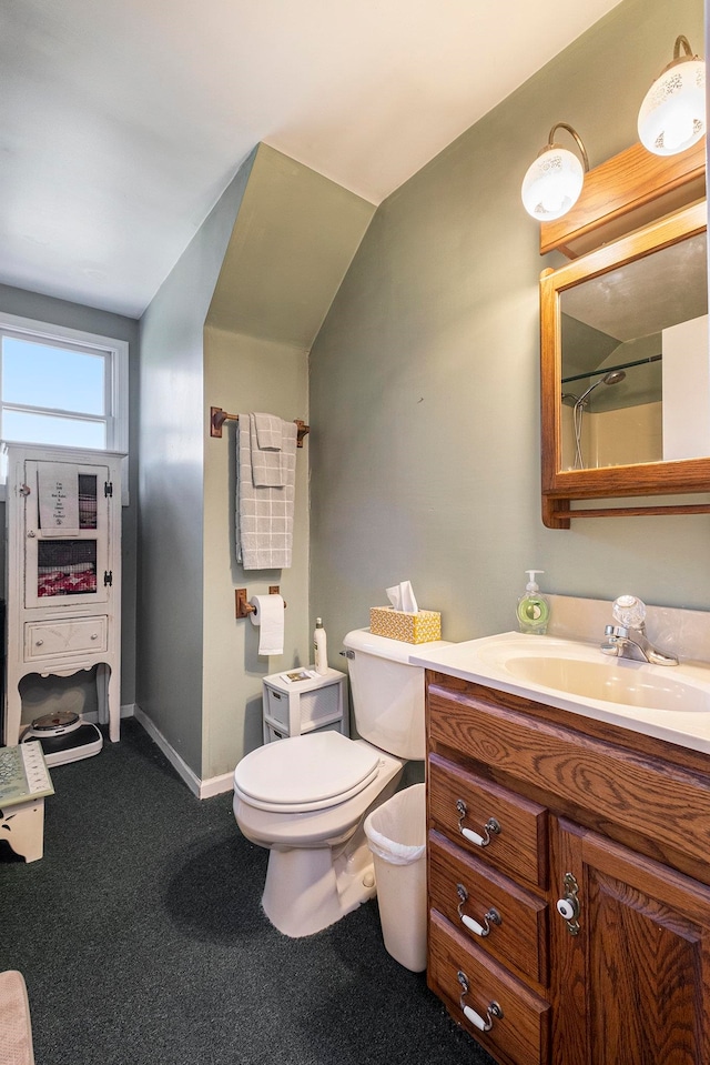 bathroom with vanity, vaulted ceiling, and toilet