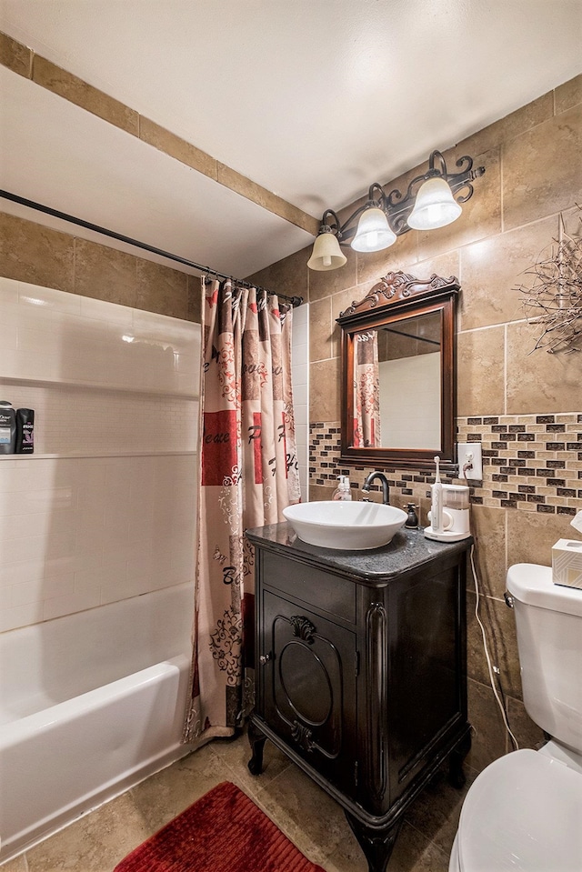 full bathroom with vanity, toilet, tile walls, and shower / tub combo with curtain