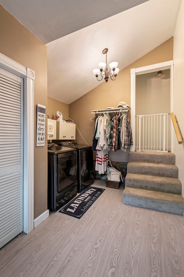 interior space with a chandelier, light hardwood / wood-style floors, vaulted ceiling, and washer and clothes dryer