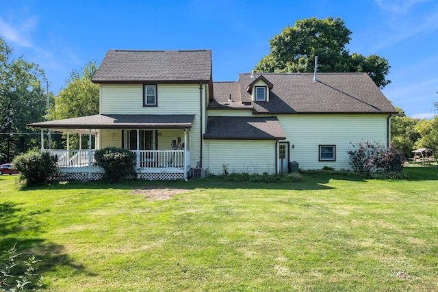 back of house featuring a lawn, a porch, and central air condition unit