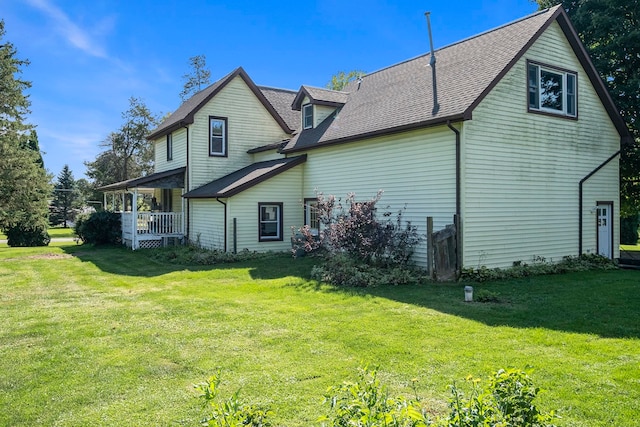 back of house with covered porch and a lawn