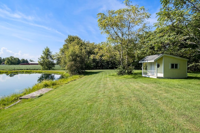 view of yard featuring a water view and a storage shed