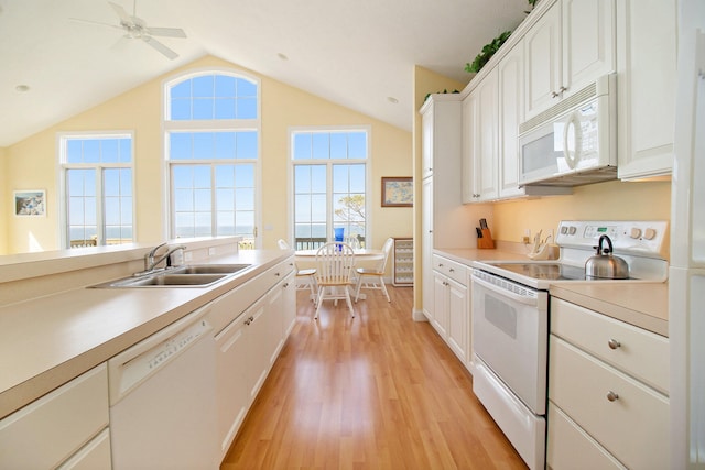 kitchen with light wood-type flooring, white appliances, sink, white cabinets, and lofted ceiling