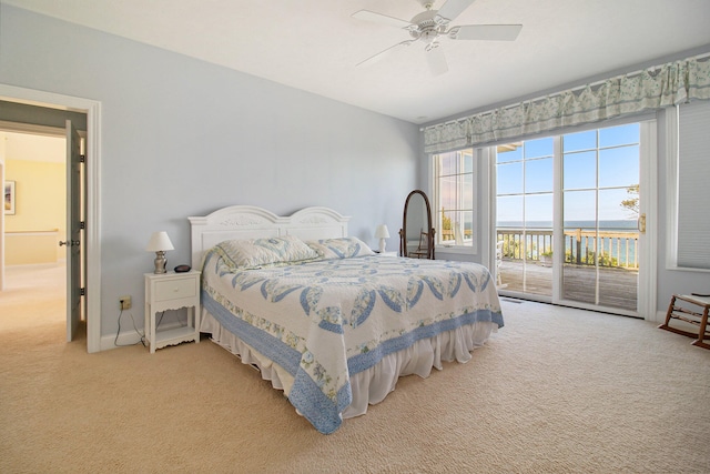 carpeted bedroom featuring ceiling fan, a water view, and access to outside