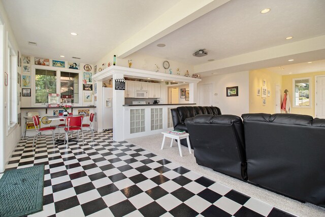 living room featuring beamed ceiling and a wealth of natural light