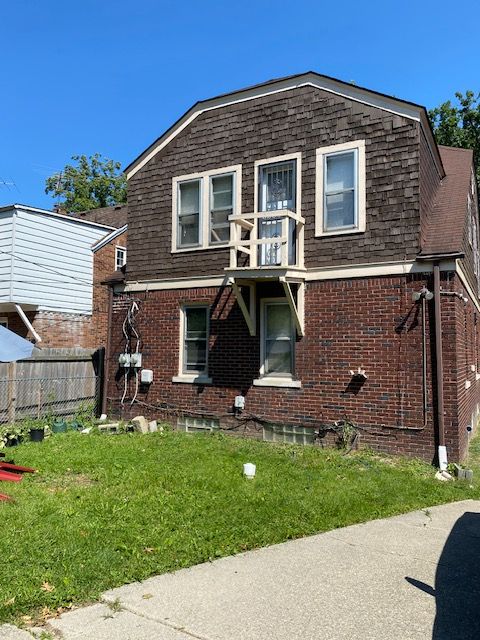 5051 Bishop St, Detroit, MI 48224 - colonial inspired home featuring brick siding, a balcony, and a shingled roof