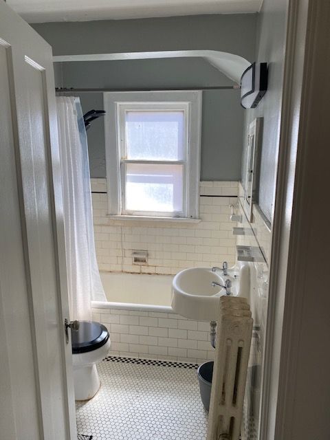 full bathroom featuring tile patterned floors, toilet, shower / bath combo with shower curtain, and sink