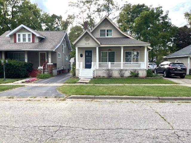 view of front of home with covered porch and a front yard