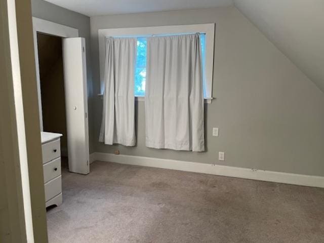 unfurnished bedroom with light carpet and vaulted ceiling