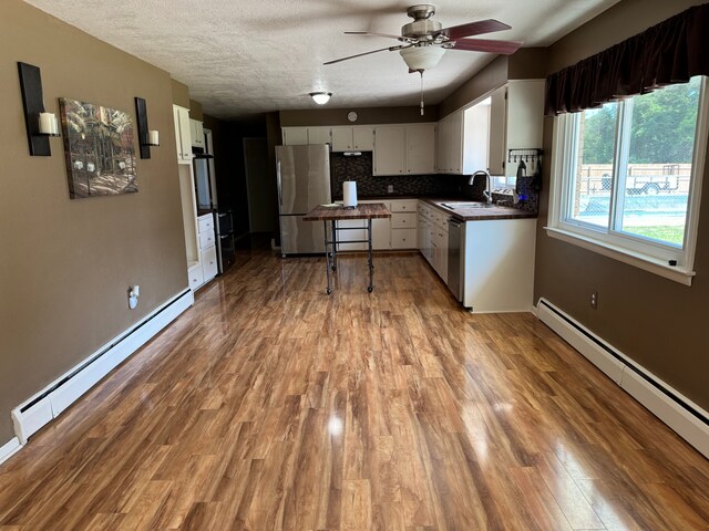 2065 S Lapeer Rd, Lapeer, MI 48446 - kitchen featuring appliances with stainless steel finishes, a baseboard radiator, a sink, and decorative backsplash