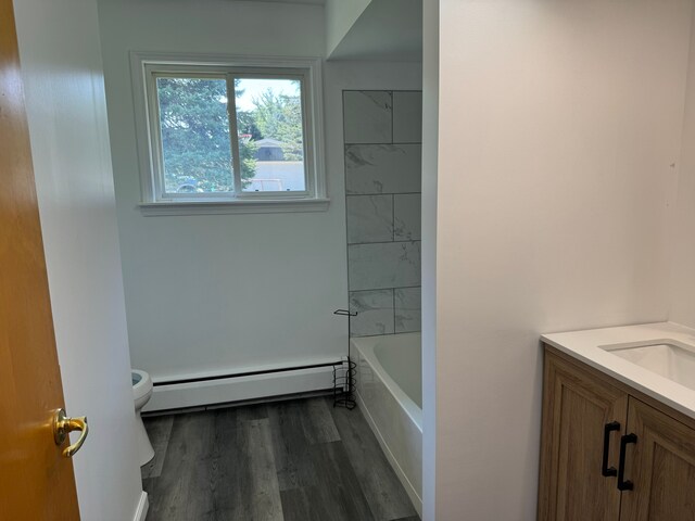 2065 S Lapeer Rd, Lapeer, MI 48446 - bathroom with a baseboard heating unit, vanity, toilet, and wood finished floors