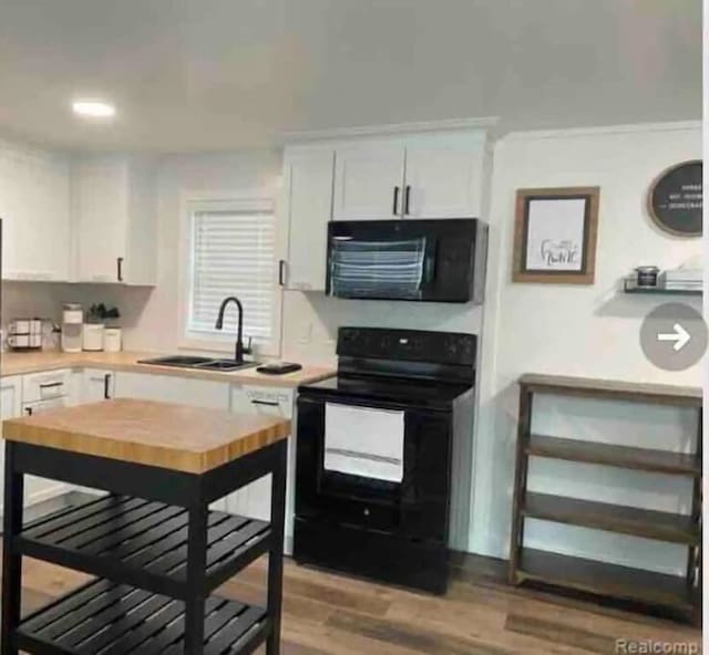 kitchen featuring black appliances, wood-type flooring, white cabinetry, and sink