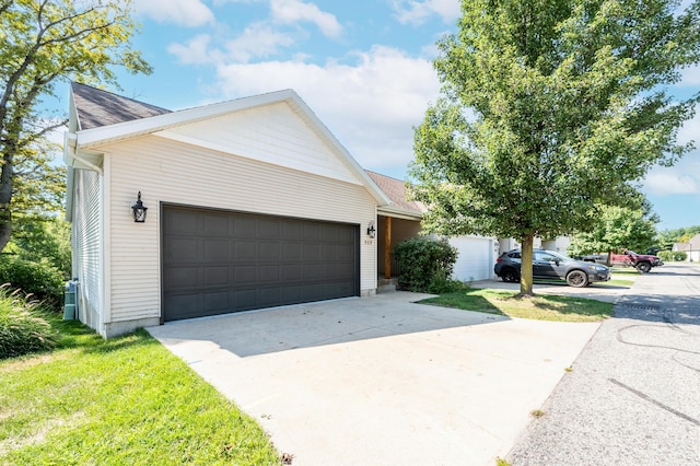 717 Tioga Park Unit 717, Big Rapids, MI 49307 - view of front of house featuring an attached garage, driveway, and a shingled roof