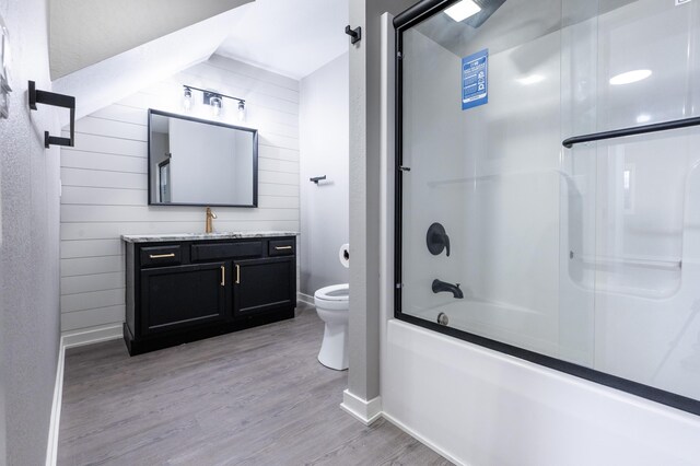 717 Tioga Park Unit 717, Big Rapids, MI 49307 - bathroom with vanity, toilet, wood finished floors, baseboards, and bath / shower combo with glass door