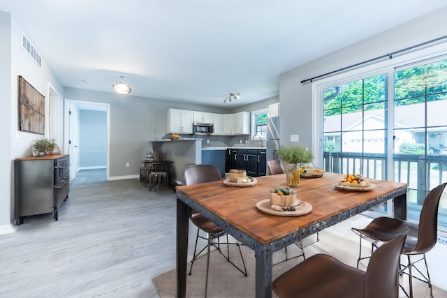 dining area with light wood-type flooring and sink