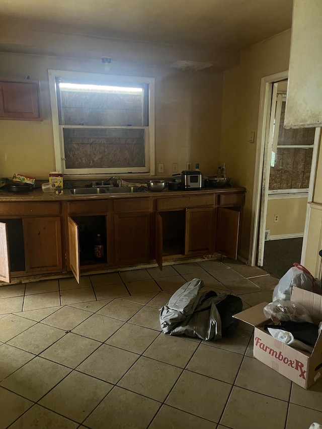 kitchen with light tile patterned floors and sink