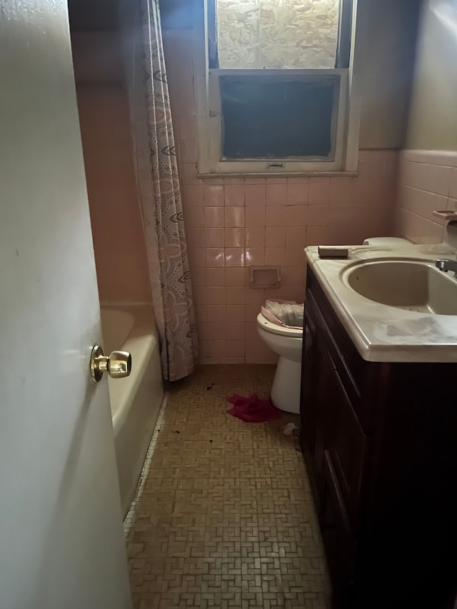 full bathroom with vanity, toilet, tile walls, and shower / bath combo with shower curtain