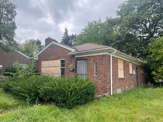5130 E Outer Dr, Detroit, MI 48234 - view of home's exterior with brick siding and a chimney