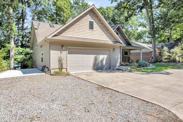 view of front of house with an attached garage, driveway, and a shingled roof