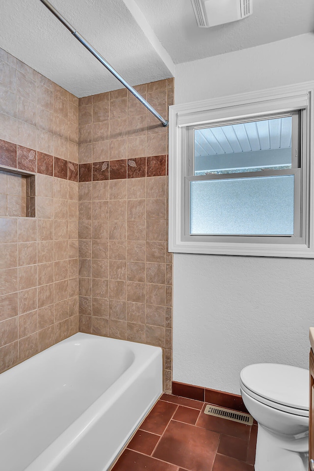 full bathroom with visible vents, a textured ceiling, toilet, and baseboards