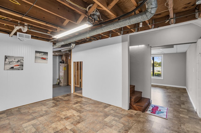 basement with stairs, gas water heater, stone finish floor, and visible vents