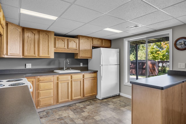 kitchen featuring dark countertops, visible vents, freestanding refrigerator, and a sink