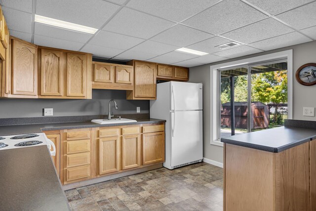 1620 Little Dr, Horton, MI 49246 - kitchen featuring white appliances, a sink, dark countertops, a drop ceiling, and baseboards