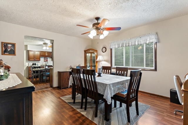 dining space featuring a textured ceiling, dark hardwood / wood-style flooring, and ceiling fan