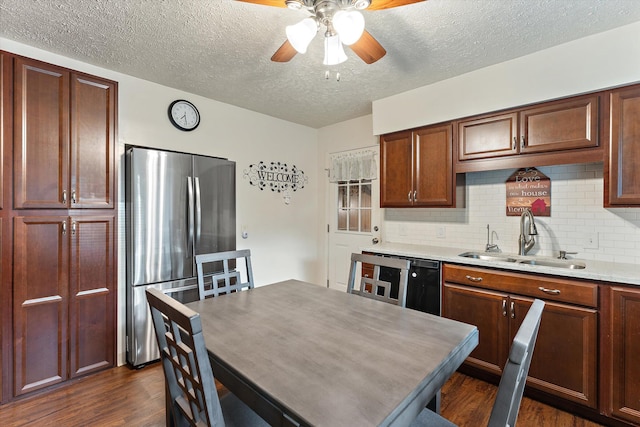 kitchen featuring sink, dark hardwood / wood-style floors, stainless steel fridge, ceiling fan, and a textured ceiling