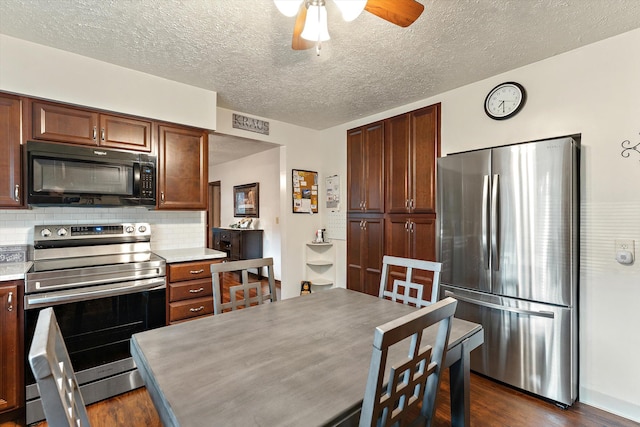 kitchen with backsplash, ceiling fan, stainless steel appliances, and dark hardwood / wood-style floors