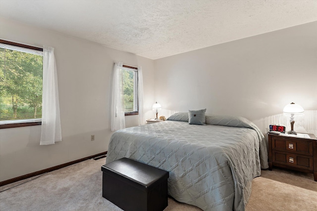 bedroom featuring a textured ceiling and light colored carpet