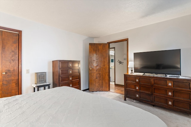 bedroom featuring light carpet and a textured ceiling