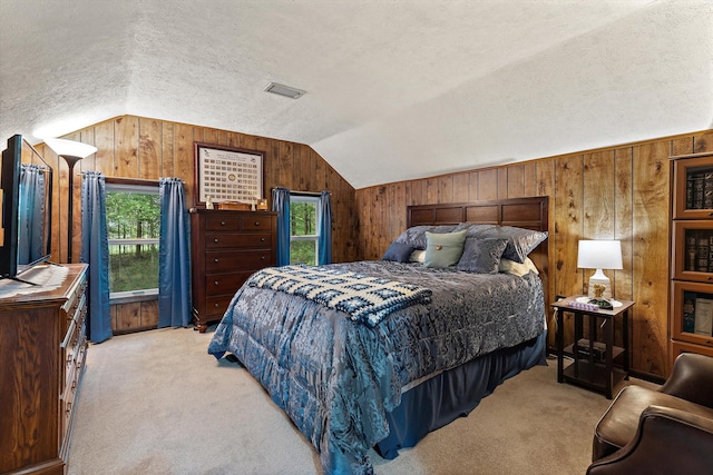 carpeted bedroom with lofted ceiling, wooden walls, and a textured ceiling