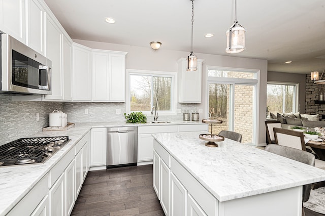 kitchen with white cabinetry, sink, a kitchen bar, a center island, and stainless steel appliances