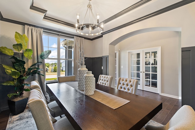 dining area with french doors, ornamental molding, a tray ceiling, dark hardwood / wood-style flooring, and a chandelier