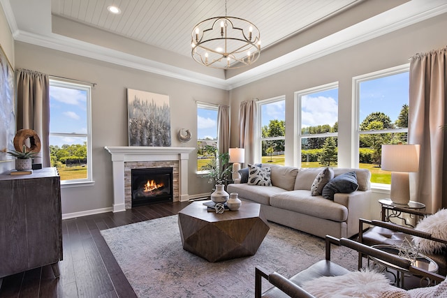 living room with a fireplace, dark hardwood / wood-style floors, a chandelier, and a healthy amount of sunlight