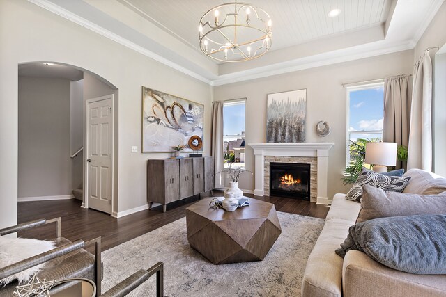 00 Hidden River Dr, Armada, MI 48005 - living room with a tray ceiling, a chandelier, arched walkways, dark wood-style floors, and a stone fireplace