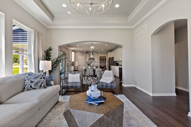 00 Hidden River Dr, Armada, MI 48005 - living room with a chandelier, a tray ceiling, arched walkways, dark wood-type flooring, and ornamental molding