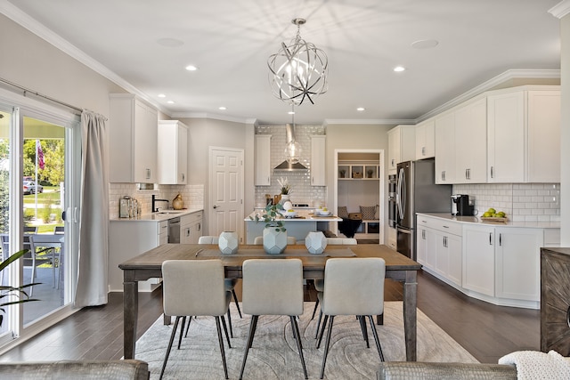 kitchen with tasteful backsplash, ornamental molding, white cabinets, dark hardwood / wood-style floors, and hanging light fixtures