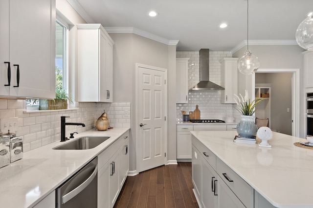 kitchen featuring white cabinets, wall chimney range hood, dark hardwood / wood-style floors, decorative light fixtures, and stainless steel appliances