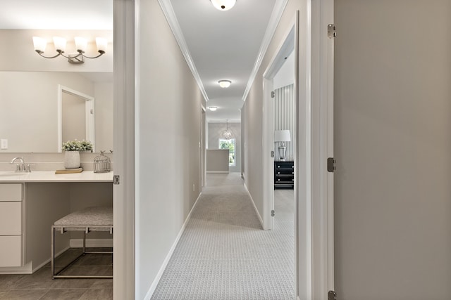 corridor featuring crown molding, sink, and light colored carpet