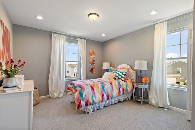 bedroom with light carpet and multiple windows