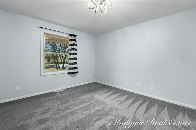 empty room with baseboards, visible vents, and dark colored carpet