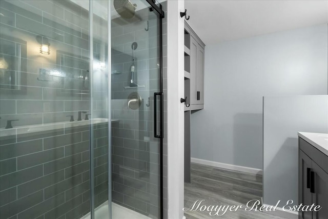 bathroom with a shower stall, vanity, and wood finished floors