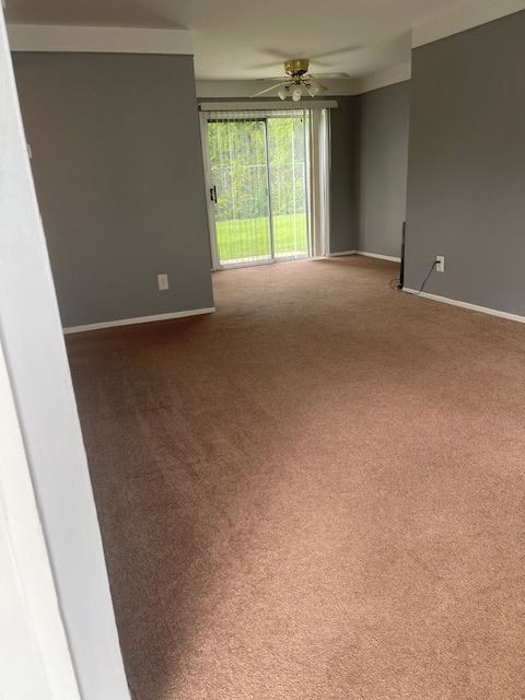 carpeted spare room featuring ceiling fan