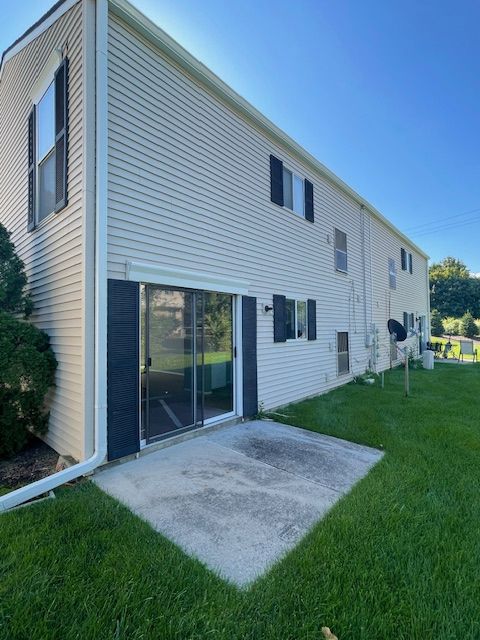 back of property featuring a yard and a patio