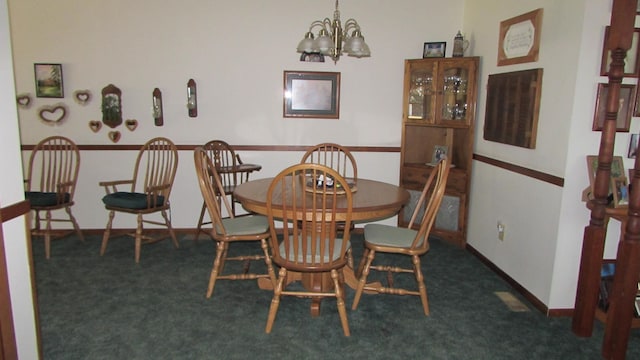 dining space with a notable chandelier and dark carpet