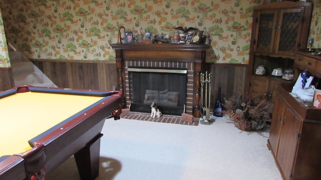 game room with light carpet, a brick fireplace, wooden walls, and pool table